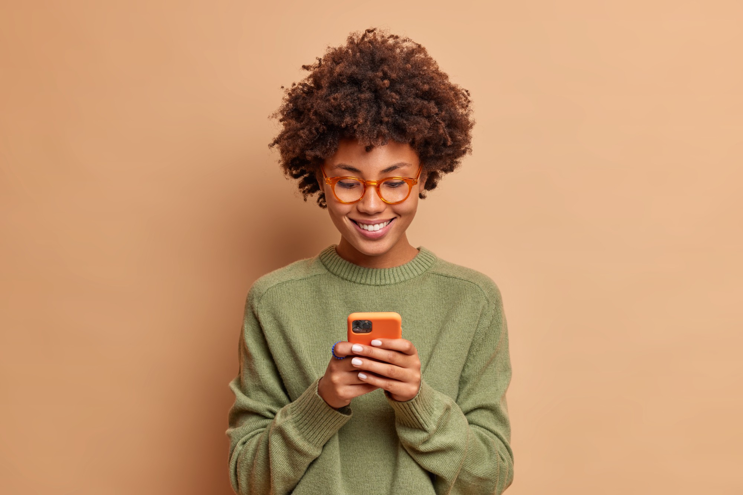 dark skin smiling person holding orange phone