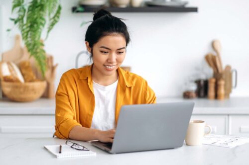 Asian person working on laptop