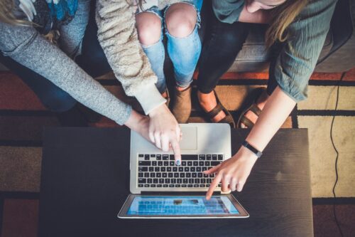 hands pointing to laptop